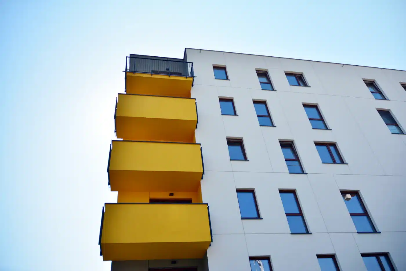 Moderne Wohnanlage mit gelben Balkonen als Kapitalanlage